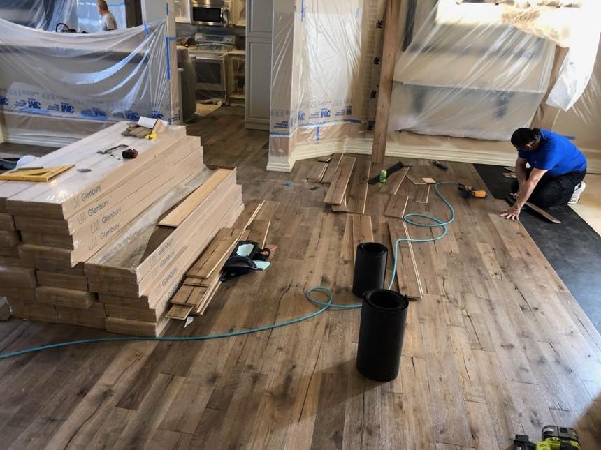 TWG crew member laying new hardwood flooring on an interior remodel in Wichita